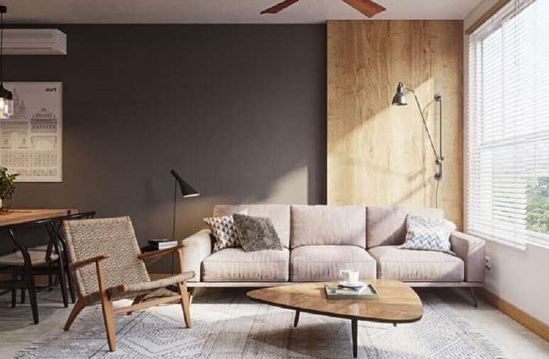 91. Sofá moderno para sala decorada com parede cinza e móveis de madeira – Foto: HomeIt