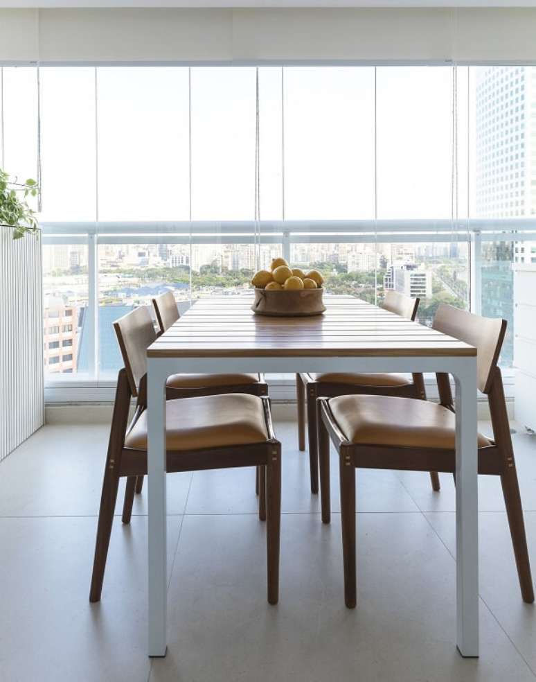 23. Cadeiras e mesa de madeira e persiana branca. Projeto por MIS Arquitetura e Interiores