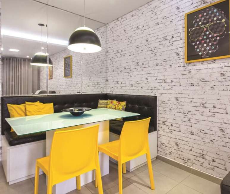 44. Mesa de jantar de canto, papel de parede tijolinho e cadeiras amarelas. Projeto por Carol Rivelli