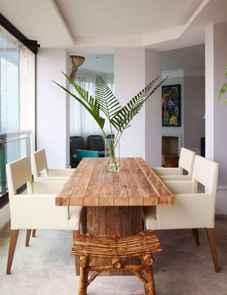 1. Mesa de jantar de madeira e cadeiras de couro branco. Projeto por Paulo Carvalho