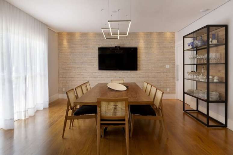 50. Mesa de jantar de madeira e estante metálica. Projeto por Gabriela Toledo, Gabriela Toledo Arquitetura e Interiores