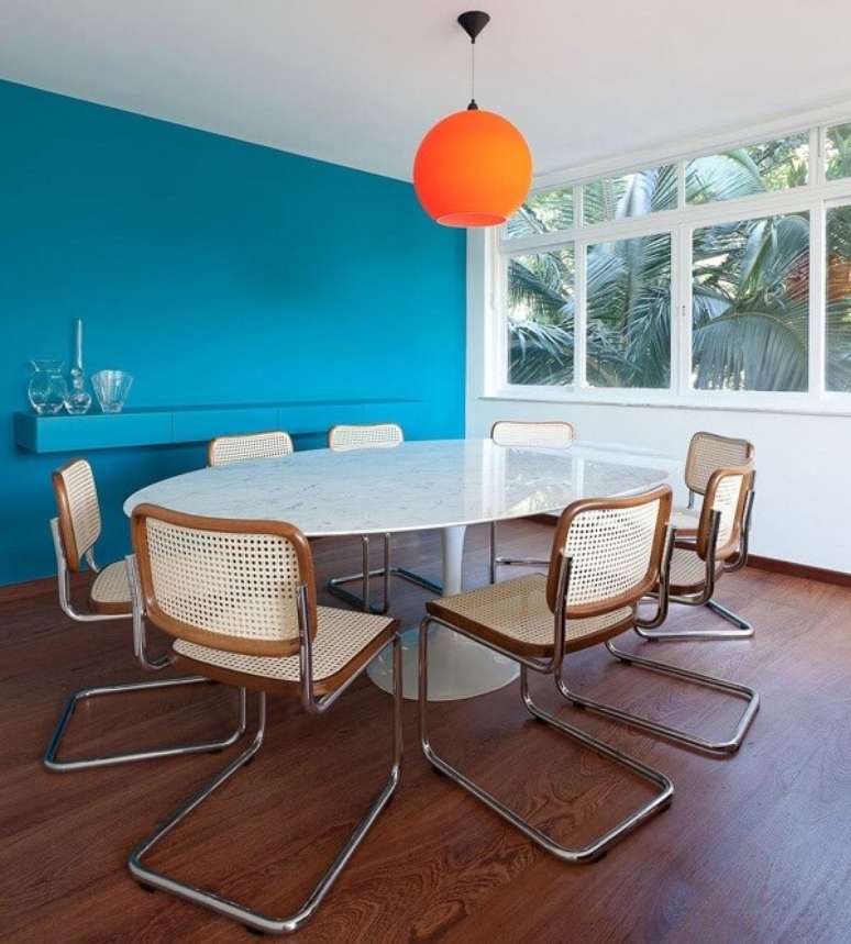 62. Mesa de jantar redonda com tampo de granito e pendente laranja. Projeto por Suite Arquitetos