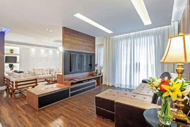 55. Sala ampla decorada com rack com painel para TV – Foto: Azoni Arquitetura