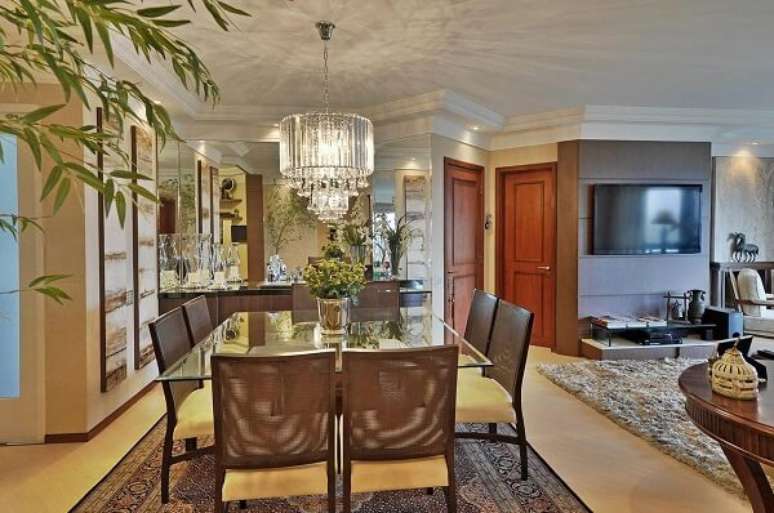 83. Sala com mesa de jantar de vidro e lustre. Projeto por Bender Arquitetura