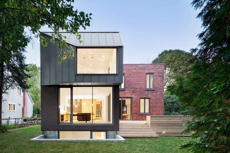 12. Casa em formato de L com paredes de vidro e tijolinho a vista – Foto: Nature Humaine