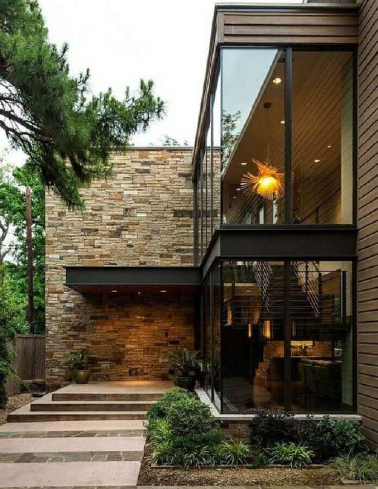 25. Linda casa em L moderna com parede revestida de pedra e grandes paredes de vidro para ajudar na iluminação – Foto: Pinterest