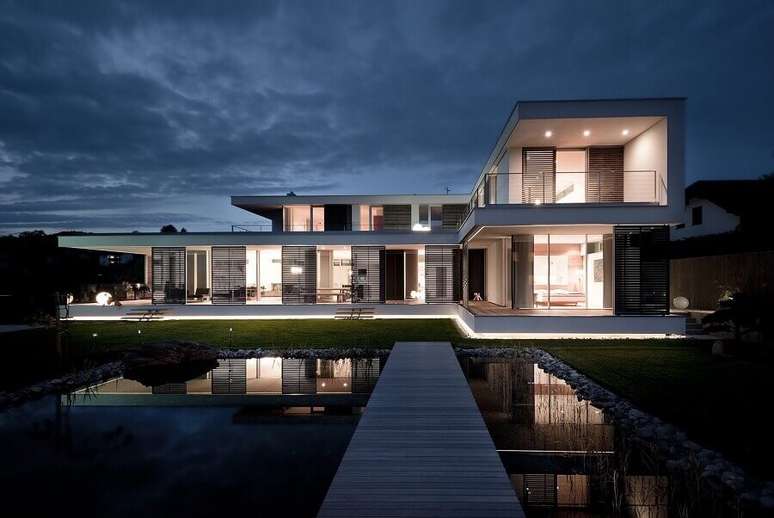 34. Casa moderna em formato de L com paredes de vidro e piscina – Foto: ArchDaily