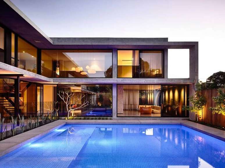 47. Lindo modelo de casa em L com piscina e parede de vidro – Foto: Pinterest