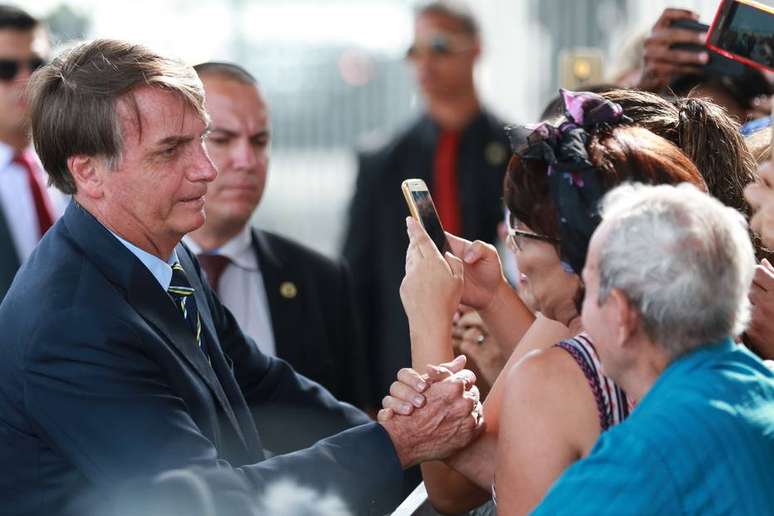 O presidente Jair Bolsonaro cumprimenta apoiadores na entrada do Palácio da Alvorada