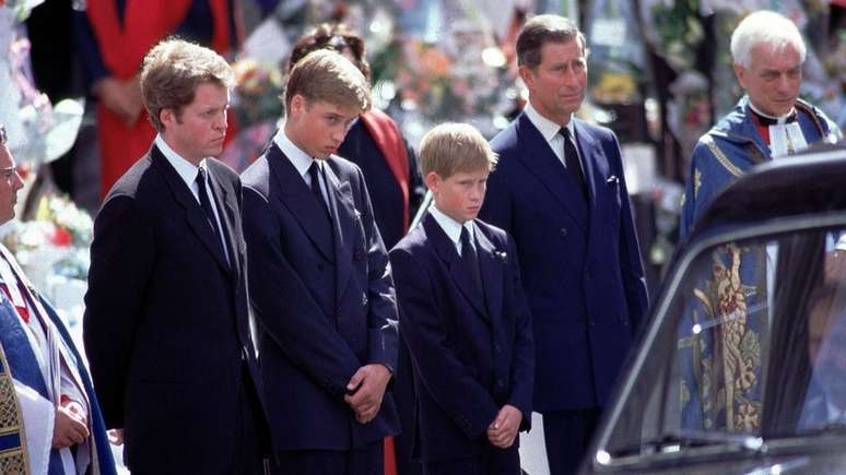 Pr&iacute;ncipe Harry ficou ao lado do pai, pr&iacute;ncipe Charles, e do irm&atilde;o mais velho, pr&iacute;ncipe William, enquanto viam o carro f&uacute;nebre carregar o caix&atilde;o de Diana