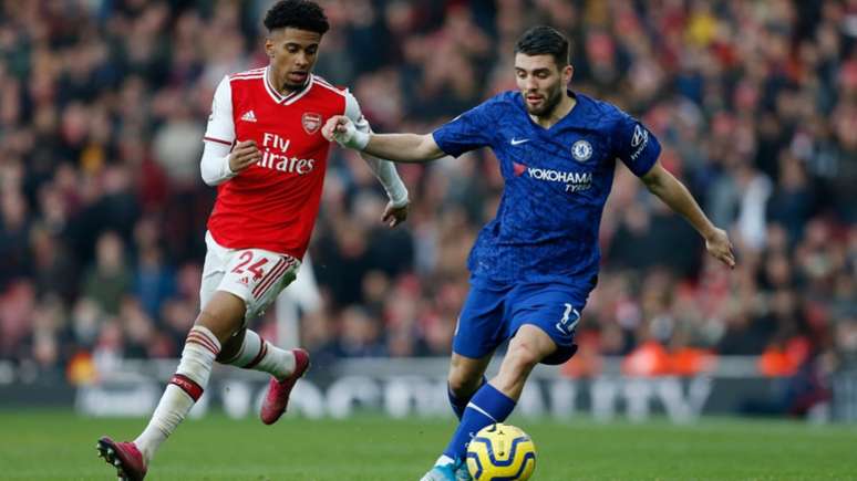 Reiss Nelson e Kovacic disputando a bola no primeiro jogo das equipes (Foto: IAN KINGTON / IKIMAGES / AFP)