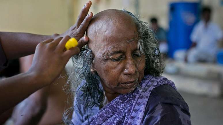 A devota hindu Rani raspou a cabeça em um templo na Índia: ela fez doação do cabelo depois de pedir por um neto