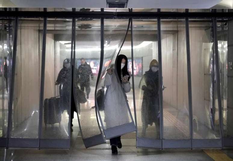 Pessoas com máscara de proteção atravessam passagem subterrânea do metrô de Pequim
21/01/2020
REUTERS/Jason Lee
