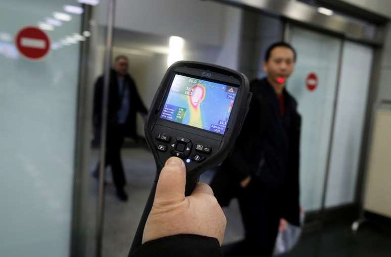 Agente do serviço sanitário epidemiológico usa scanner térmico para detectar sinal de febre em passageiros que chegam da China no aeroporto de Almaty, no Cazaquistão
21/01/2020
REUTERS/Pavel Mikheyev
