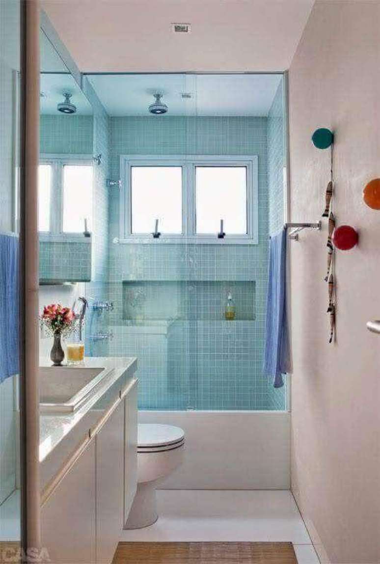 29. Banheiro de apartamento pequeno decorado simples com pastilhas azuis na área do box – Foto: Casa Perferies