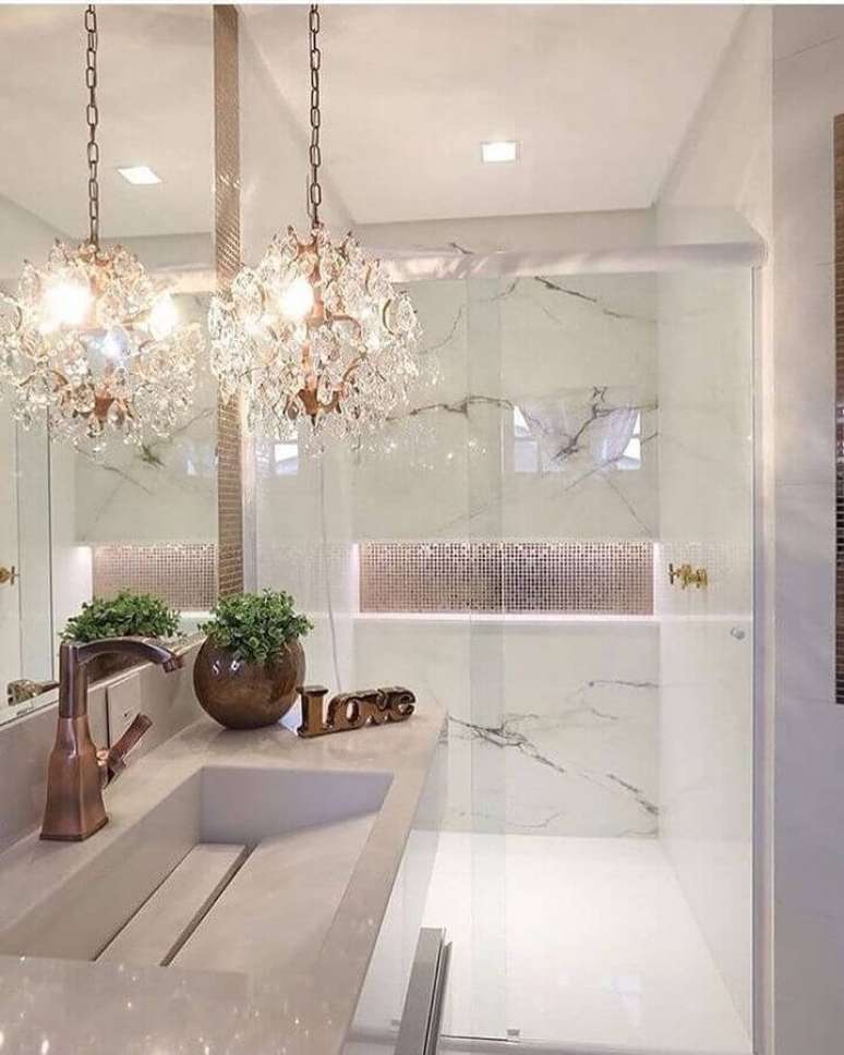 9. Decora&ccedil;&atilde;o para banheiro de apartamento de luxo com lustre de cristal e m&aacute;rmore branco &ndash; Foto: Pinterest