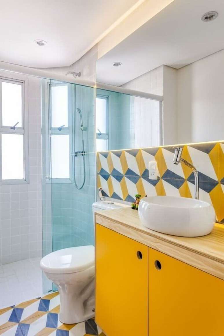 44. Decoração simples com revestimento colorido e gabinete amarelo para banheiro de apartamento pequeno decorado – Foto: Construção & Design