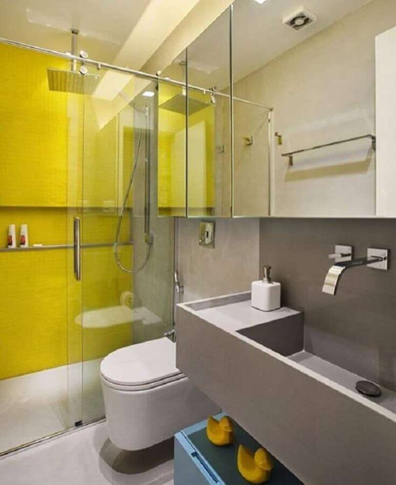 52. Decoração para banheiro de apartamento moderno com revestimento amarelo na área do box e bancada cinza – Foto: Roberta Devisate