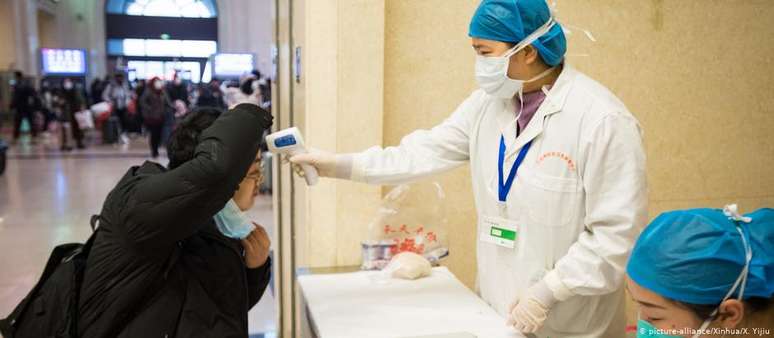 Médica examina passageiro na estação de Wuhan, cidade que se tornou centro do surto de misteriosa pneumonia viral