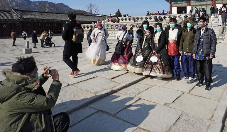 Grupo de turistas em ponto conhecido da China usa máscara para evitar contaminação