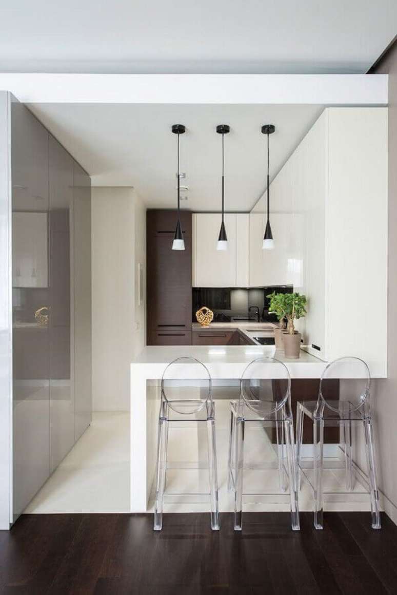55. Cozinha planejada pequena decorada com bancada branca e banquetas modernas de acrílico transparente – Foto: Archidea