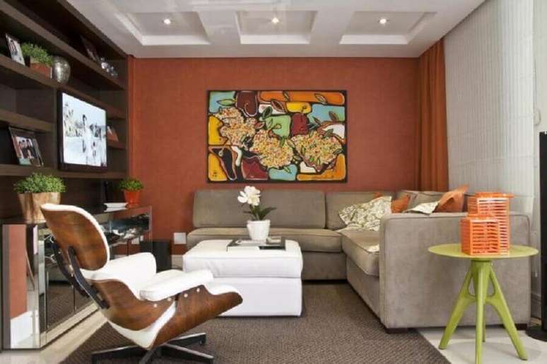 21. Sala de estar decorada com cor de parede terracota e sof&aacute; de canto cinza &ndash; Foto: Arquitetando