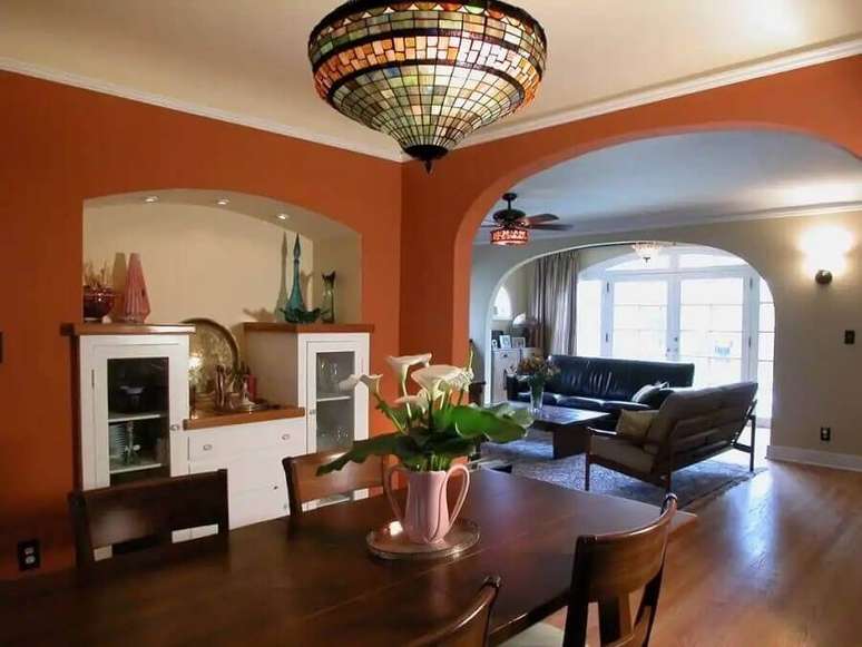 22. Sala de jantar com parede na cor terracota e mesa de madeira – Foto: Pinterest