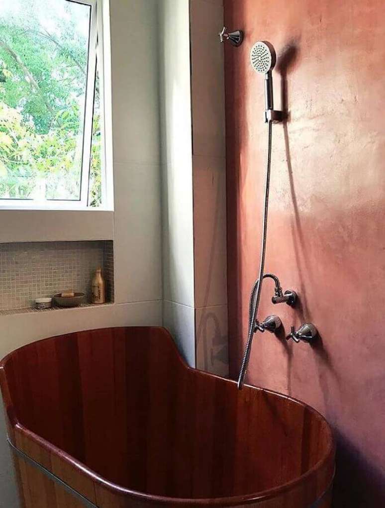 24. Cor terracota para banheiro com banheira de madeira – Foto: Anônimos Arquitetos