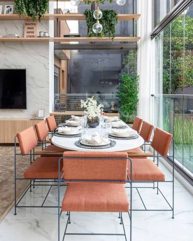 33. Casa ampla e moderna decorada com paredes de vidro e mesa de jantar com cadeiras na cor terracota – Foto: Triplex Arquitetura