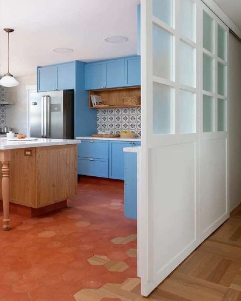 39. Piso na cor terracota para decoração de cozinha planejada com armários azuis – Foto: Pinterest