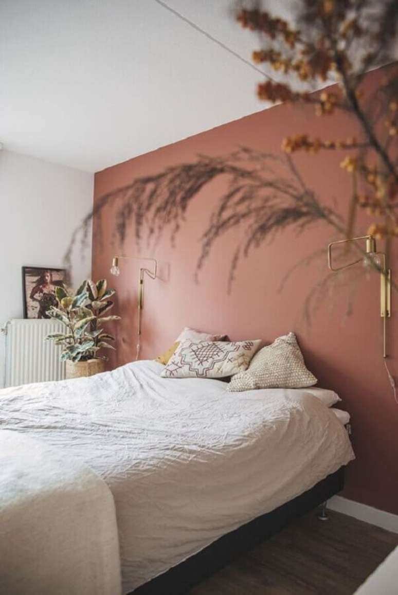 42. Quarto de casal minimalista decorado na cor de parede terracota e com vasos de plantas – Foto: Pinterest