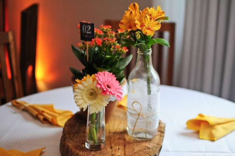 60- A decoração de noivado simples utiliza como centro de mesa garrafas com flores. Fonte: Casando Sem Grana