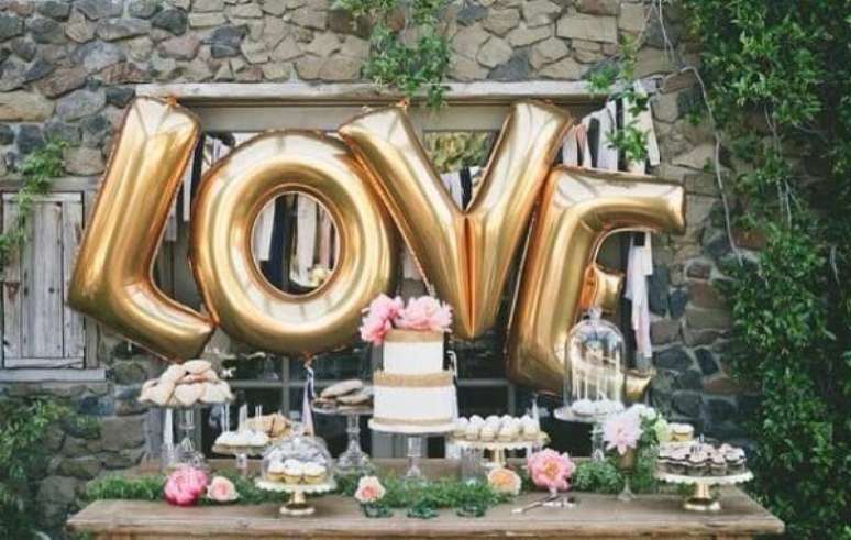 70- Balões metálicos na mesa do bolo transforma a decoração de noivado. Fonte: Planejando Meu Casamento