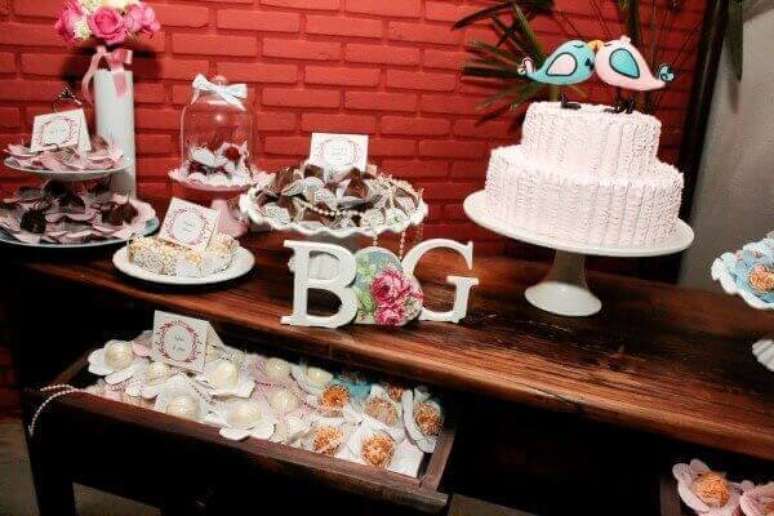 49- O casal de pombinhos sobre o bolo são uma das ideias de decoração de noivado divertidas. Fonte: roofingbrooklyn