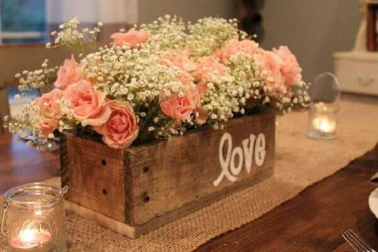 19- Na decoração de noivado a caixinha de flores com castiçais de velas proporcionam um toque delicado ao ambiente. Fonte: Casar é um Barato