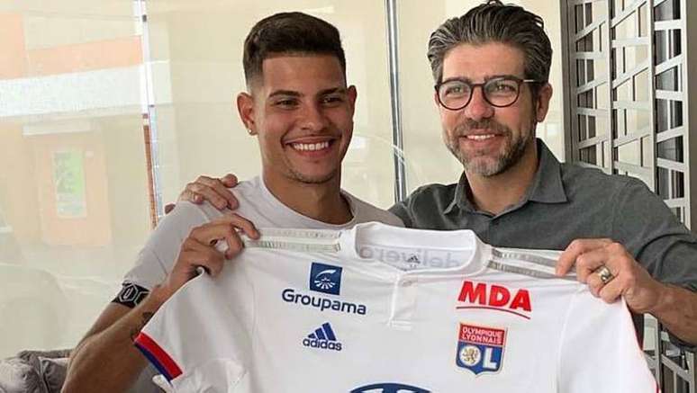 Bruno Guimarães aparece segurando camisa do Lyon ao lado de Juninho Pernambucano