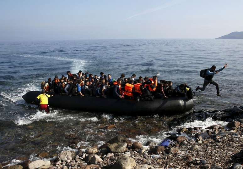 Imigrante afeg&atilde;o pula de embarca&ccedil;&atilde;o em praia na isla de  Lesbos 19/10/2015 REUTERS/Yannis Behrakis