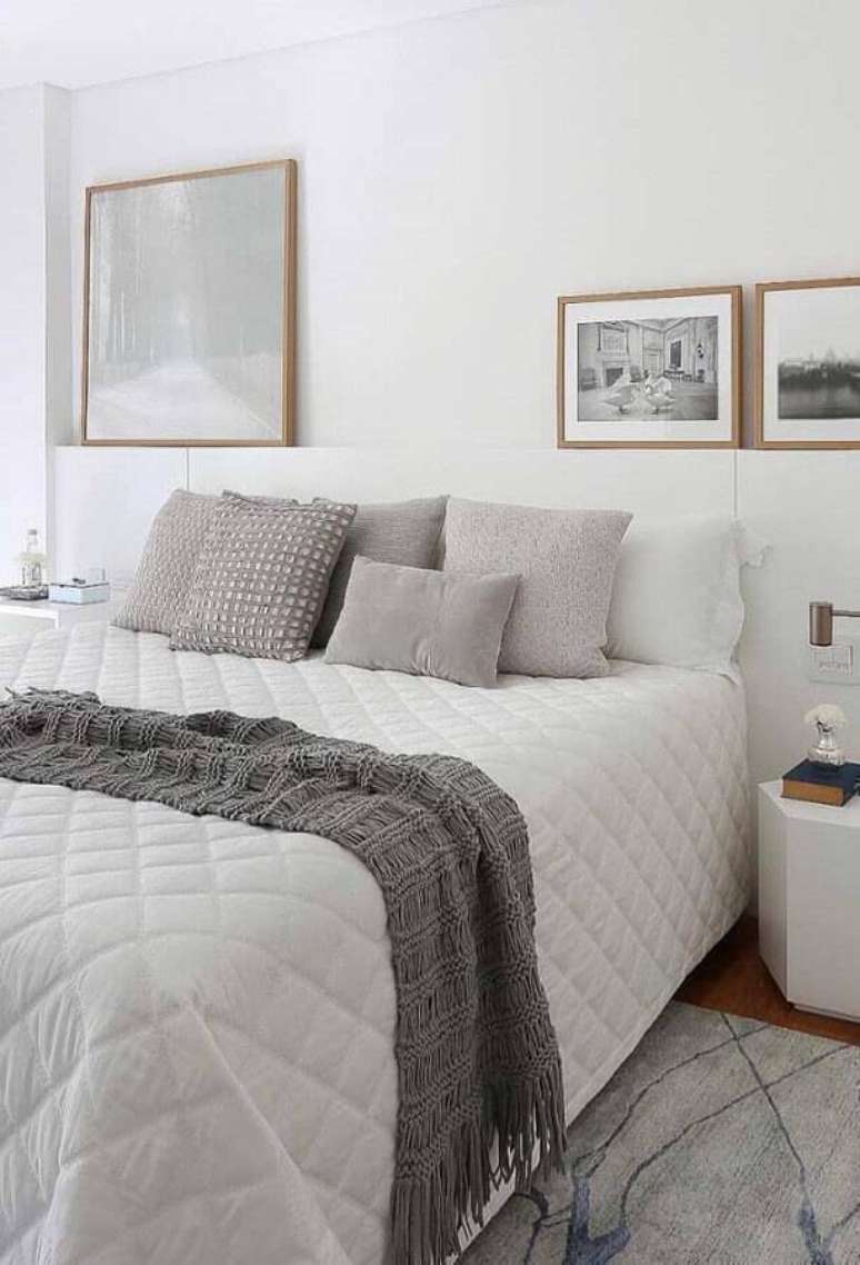 26. Decoração clean para quarto de casal branco e cinza com quadros apoiados em nicho – Foto: Pinterest