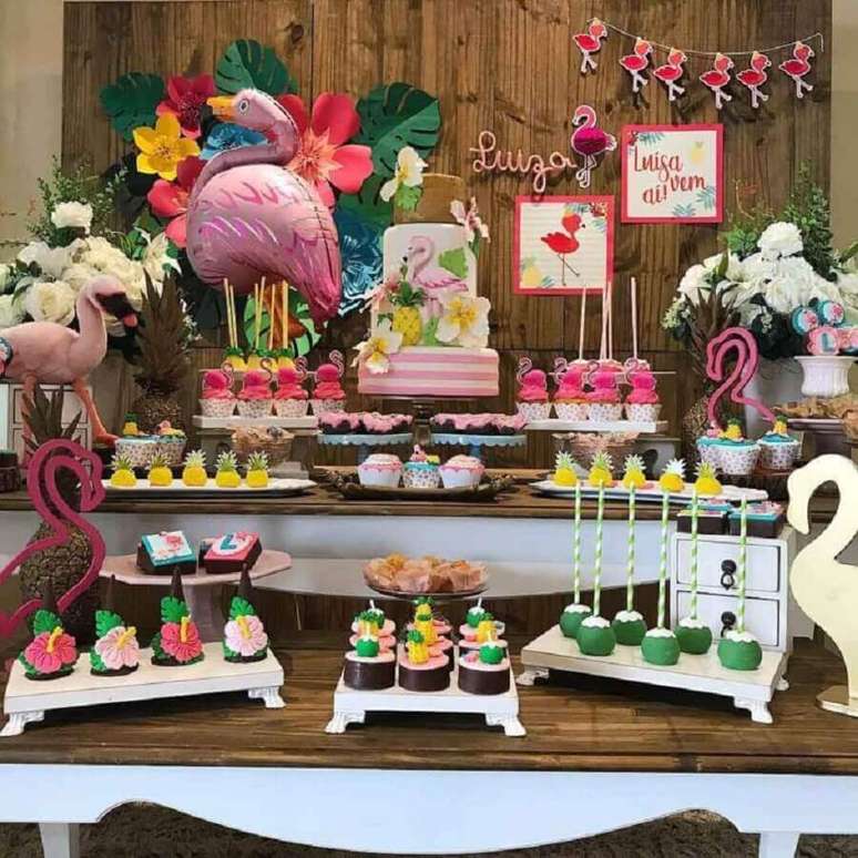 91. Mesa de festa de aniversário de flamingo decorada com doces personalizados e flamingos grandes – Foto: Rebeca Bassalo Festas
