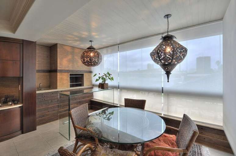 81. Varanda gourmet com bancada de vidro e lumin&aacute;rias de teto robustas &ndash; Fonte: Bender Arquitetura