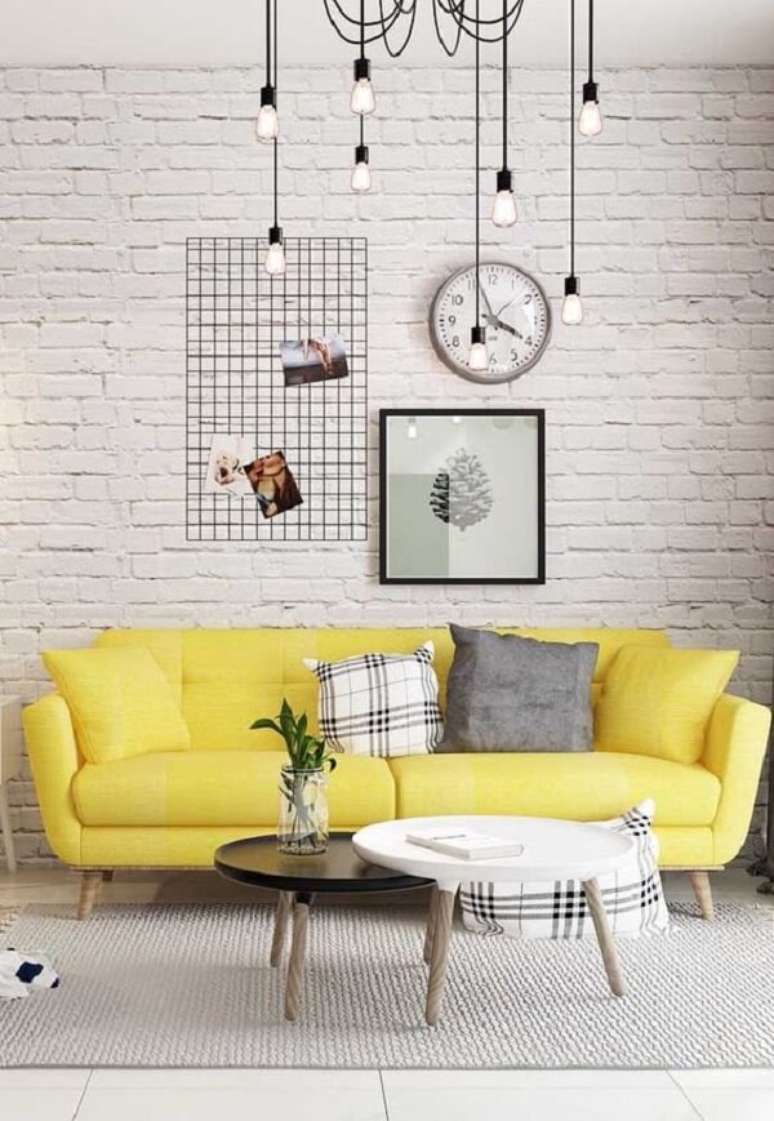 16. O sofá amarelo se destaca no ambiente com parede de tijolinho branco. Fonte: Pinterest