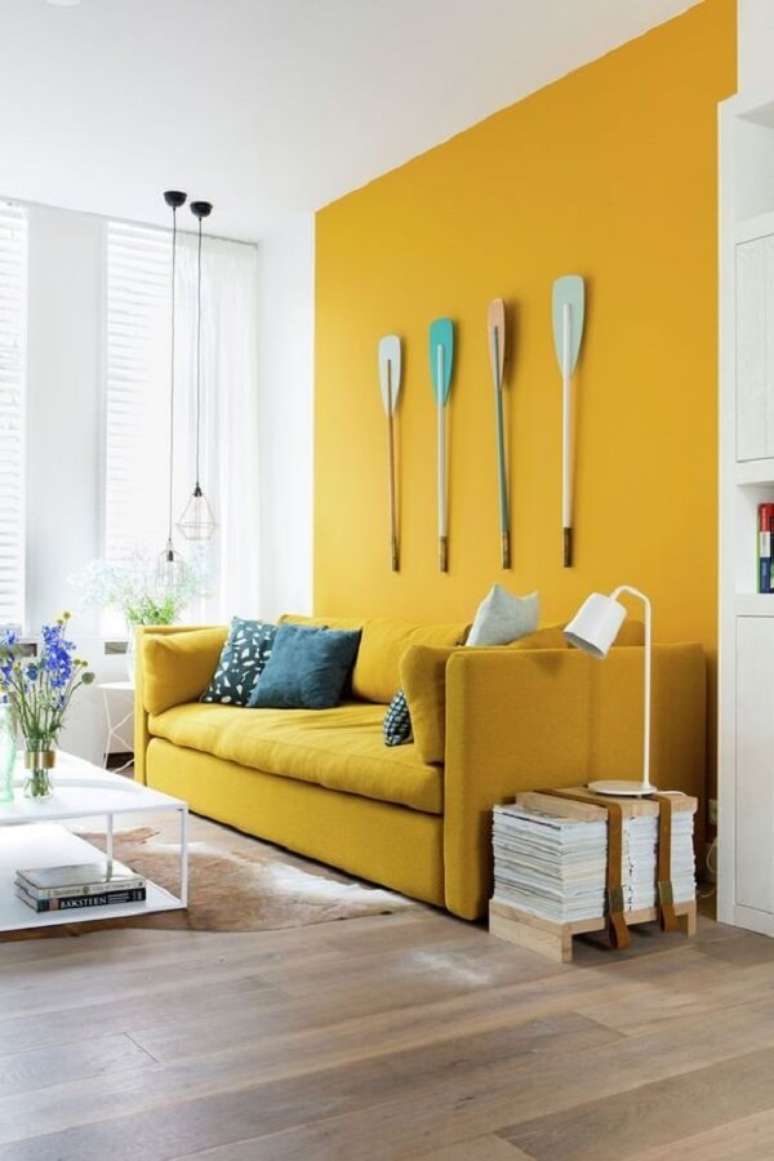 12. A parede pode seguir a mesma tonalidade do sofá amarelo. Fonte: Simplichique