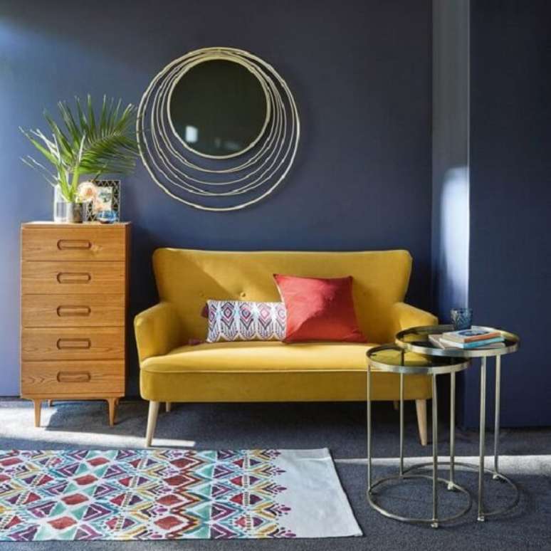 13. O sofá amarelo trouxe luminosidade para o cômodo com parede escura. Fonte: Pinterest