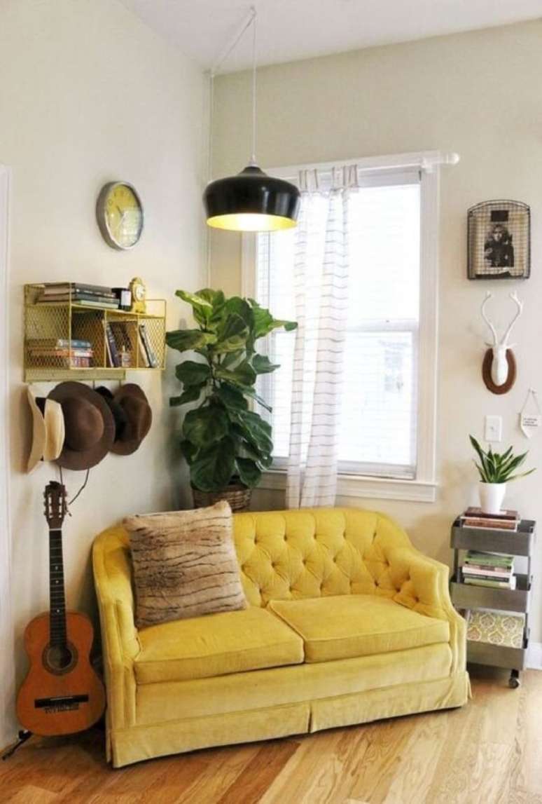 17. Sala de estar com pendente preto e sof&aacute; amarelo dois lugares. Fonte: Pinterest
