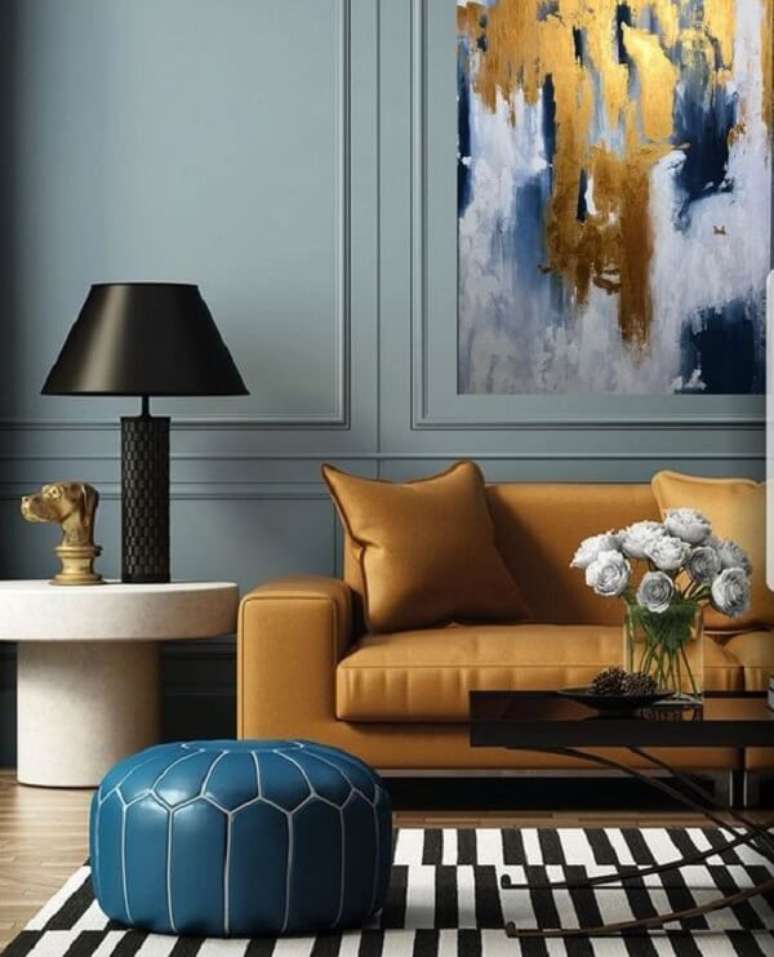 23. O sofá amarelo se harmoniza com o quadro abstrato da parede. Fonte: Boca de Lobo