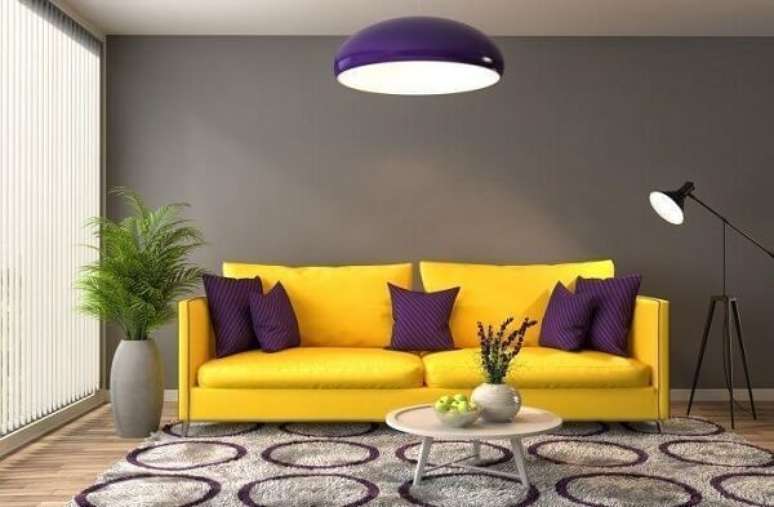 27. Sala de estar com sofá amarelo e almofadas roxas. Fonte: Pinterest