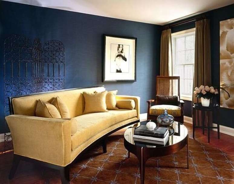 30. O sofá amarelo ilumina a sala de estar com paredes escuras. Fonte: Pinterest