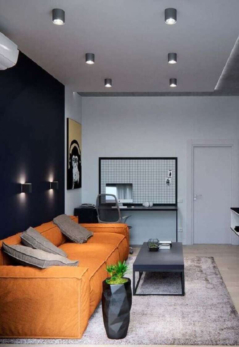 10. Decoração para sala preta moderna com sofá laranja – Foto: Pinterest