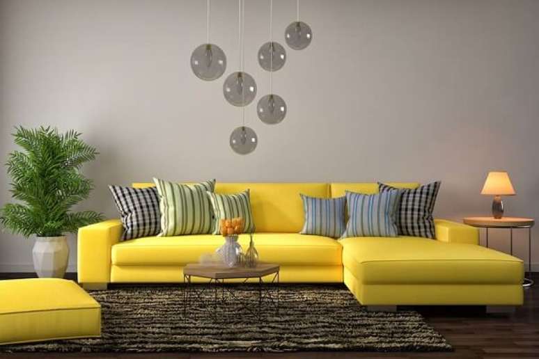 31. Modelo de sofá amarelo com chaise e almofadas listradas. Fonte: Pinterest