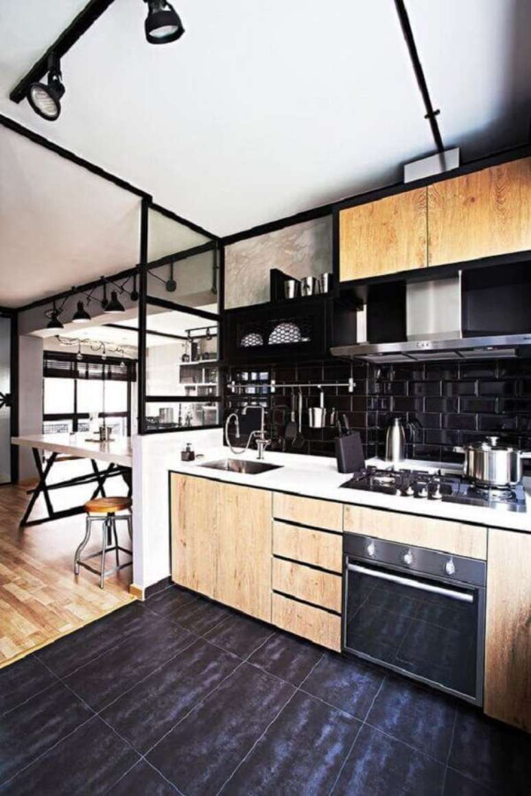 5. Os armários de madeira garantem um toque rústico e acolhedor para a cozinha com revestimento na cor preta – Foto: DecoRecent